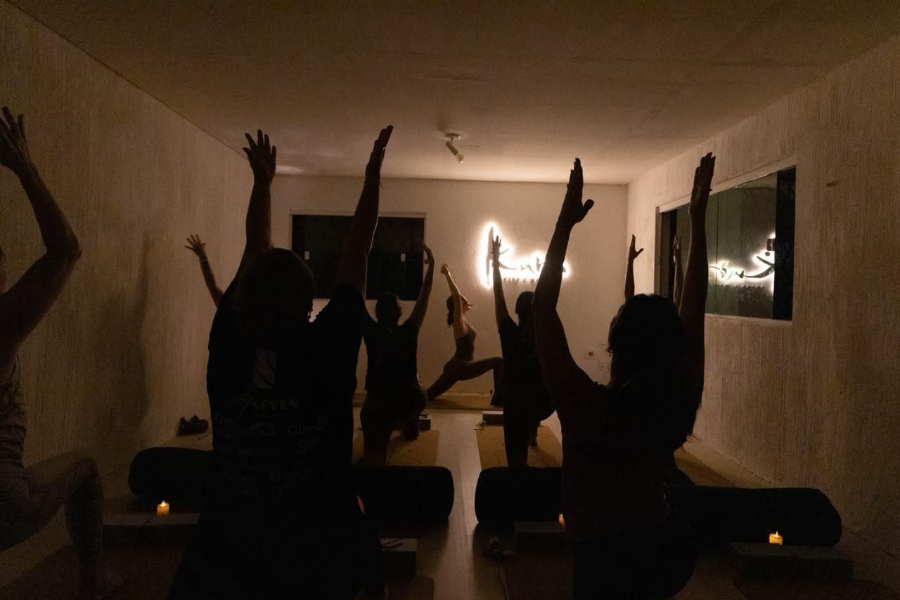 Aula noturna no Kura com alunas de braços erguidos
